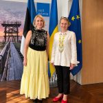 Two women standing in front of the flags of Estonia, Ukraine and the European Union