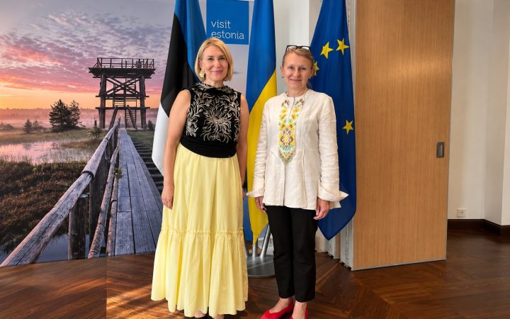 Two women standing in front of the flags of Estonia, Ukraine and the European Union