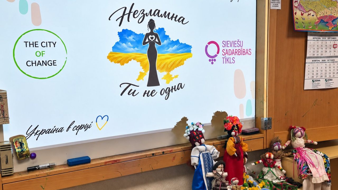 A screen reading “Nezlamna. You are not alone” and colourful motanka dolls made at the workshop