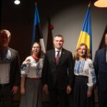 Учасники відкриття Почесного консульства України в Нарві на тлі прапорів Естонії та України